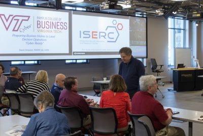 David Simpson chats with some participants at a talk on cyber readiness on campus .