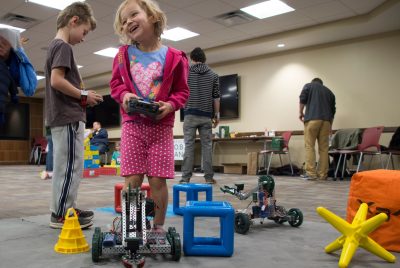 A young girl operates the controls for a remote control car.