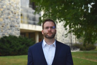 Joseph Simpson poses for a portrait near Pamplin Hall