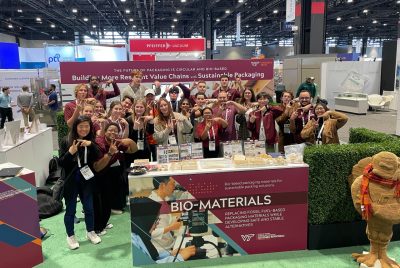 A group of people stand in front of a display on a convention floor.