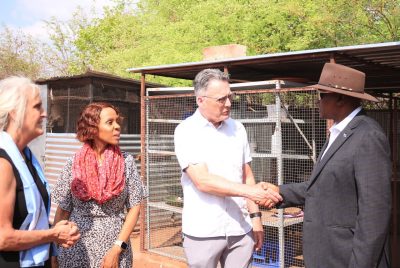 Two people shake hands, as two others look on. 