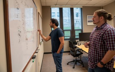 Computer scientists working at whiteboard.