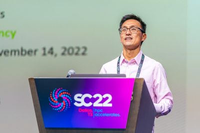 Image of Wu Feng speaking at SC22 behind a podium