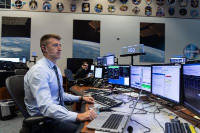 Person sits at desk with computers