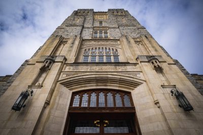 A photo looking straight up Burruss Hall tower into the blue sky.