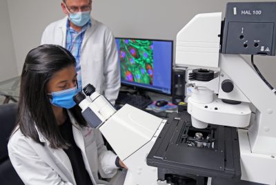 The Jutras lab, led by Brandon Jutras (left), employs many different tools to study Lyme disease. Here, Mari Davis (right) is using high-resolution fluorescent microscopy to discovery new biological features of the disease-causing bacterium, Borrelia burgdorferi.