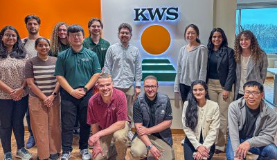 This image is of several graduate students and postdoctoral fellows in front of the KWS sign, which is an agricultural company in St. Louis, Missouri.
