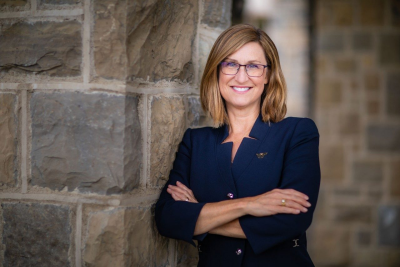 Julie Ross stands in front of a wall of Hokie Stone.
